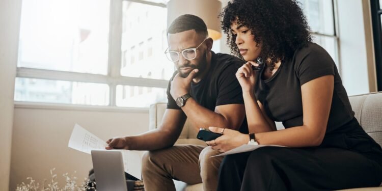 Two adults look at a laptop screen