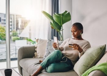 Woman sitting with phone and credit card