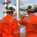 Two men looking at oil pipelines