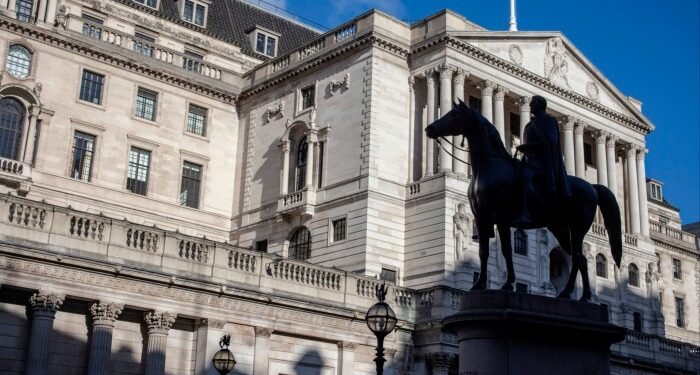 The Bank of England building on Threadneedle Street, London, with its classical architecture and columns under a clear blue sky