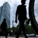 People cross a street in front of the headquarters building of the European Central Bank in Frankfurt
