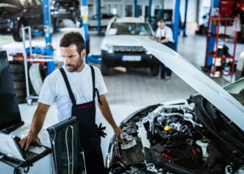 Person inspecting car engine