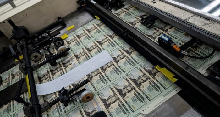 A sheet of uncut $20 bills is seen on a printing machine at the US Bureau of Engraving and Printing in Washington