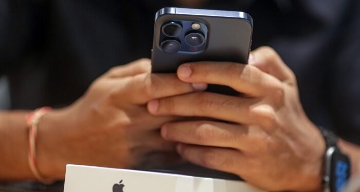 A customer uses an iPhone 15 Pro smartphone at an Apple store