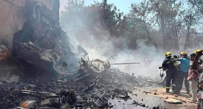 Firefighters battle to extinguish burning wreckage at the site of the plane crash in Ahmedabad on Thursday