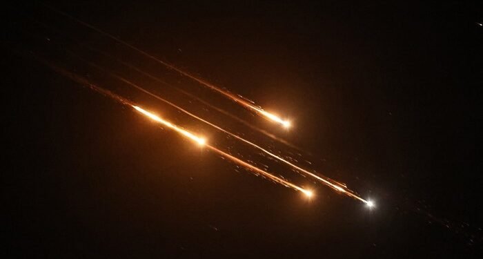 Debris of missiles fired from Iran toward Israel leave trails in the night sky over Nablus in the occupied West Bank after being intercepted on June 13, 2025
