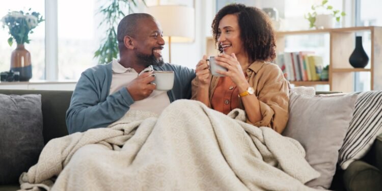 older adult couple sharing coffee on sofa