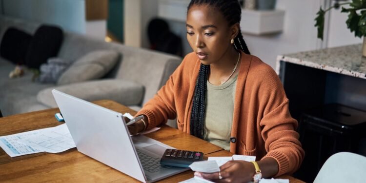 Person using a calculator and laptop.