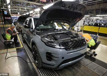 Staff are seen assembling Range Rover Evoque SUVs on the production line at Jaguar Land Rover's Halewood factory in Liverpool in December 2022 - the plant was closed on Monday