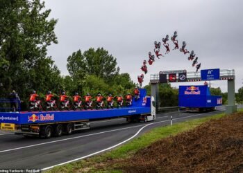 This is the moment a daredevil motocross rider jumps between two moving trucks, not only backflipping between the HGVs but also clearing a motorway gantry at the same time. But the 'meticulously planned' trick stunt doesn't go entirely to plan...