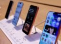 Four iPhone 17 models displayed upright on a store counter.