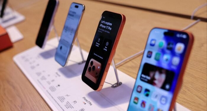 Four iPhone 17 models displayed upright on a store counter.
