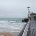 Surfers won't be the only ones taking advantage of stormy weather this weekend, some households will pay nothing for electricity. A person surfs in the sea off of Bournemouth Pier