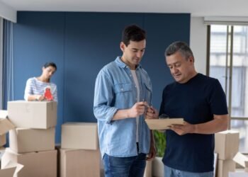 Man in home talking to moving company employee.