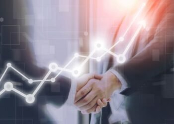 Businessman making handshake with a businesswoman on futuristic technology connection shape motion blur background with graph and chart rise up.Greeting and dealing business success concepts.