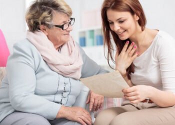 Shot of a young woman reading an old letter and her mother looking at her