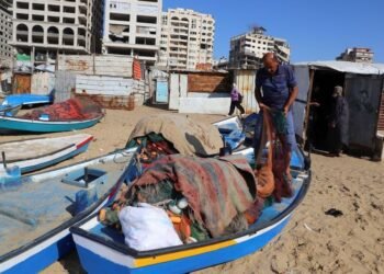 Gazan fishermen patch up dinghies with door frames to keep themselves afloat