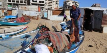 Gazan fishermen patch up dinghies with door frames to keep themselves afloat