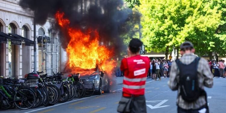 Protesters smash windows and set Tesla ablaze in anti-G7 march in Geneva